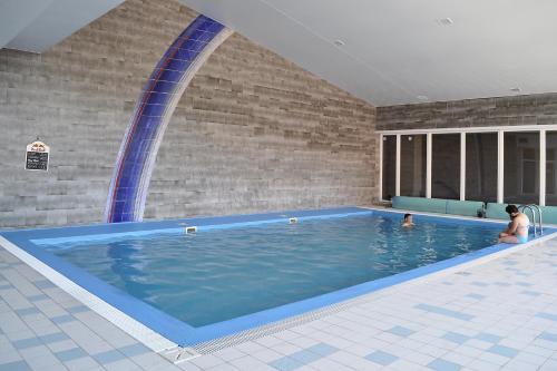 a large swimming pool with a woman in the water at Apartman 4 Vsemina Valassko in Všemina