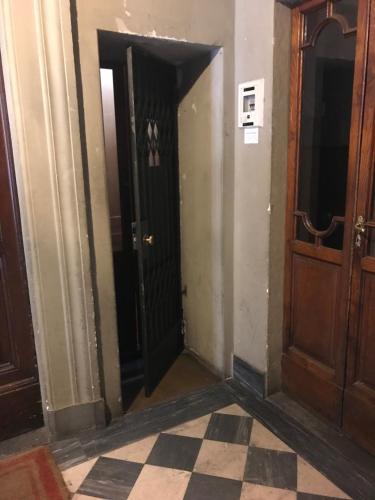 a hallway with two doors and a checkered floor at Hotel Giglio in Florence