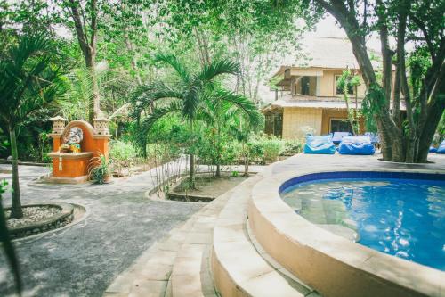 a backyard with a swimming pool and a house at Alam Gili Trawangan by Mahaputra in Gili Trawangan