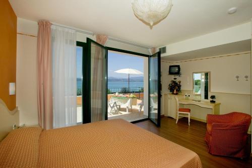 a bedroom with a bed and a view of the ocean at Hotel La Rondine in Sirmione