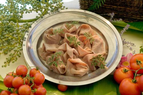 a bowl of dumplings with tomatoes on a table at Hotel La Rondine in Sirmione