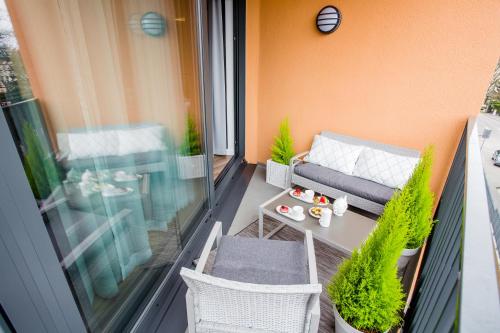 a balcony with a couch and a table and chairs at Horyzont Luksusowe apartamenty nad morzem z parkingiem Międzyzdroje in Międzyzdroje