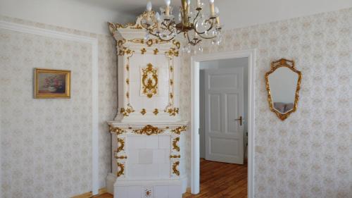 a room with a chandelier and a white fireplace at Sunshine apartment in Liepāja