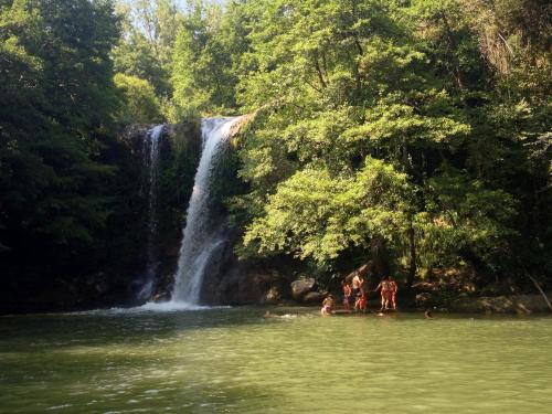 a group of people standing in the water in front of a waterfall at Can Nofre - Masia familiar en zona tranquila in Amer
