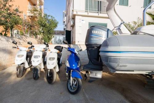 a group of three scooters parked next to a plane at Maki Apartments in Hvar