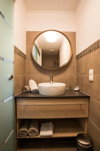 a bathroom with a sink and a mirror at Pension Julia & Haus Elisabeth - Wallner's Hofheuriger & Weinhof in Mörbisch am See