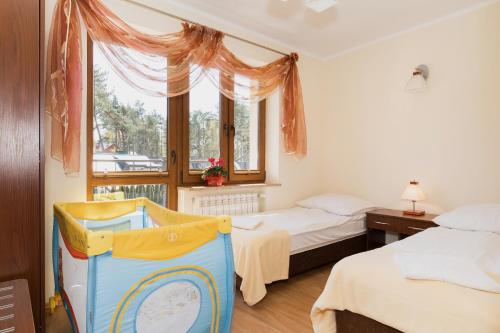 1 dormitorio con 2 camas y ventana en OW Diament, en Pobierowo