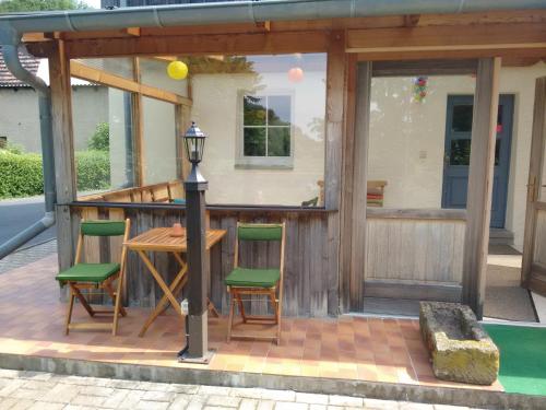 a house with a table and chairs on a patio at Pension Elbkiosk in Kleinzadel