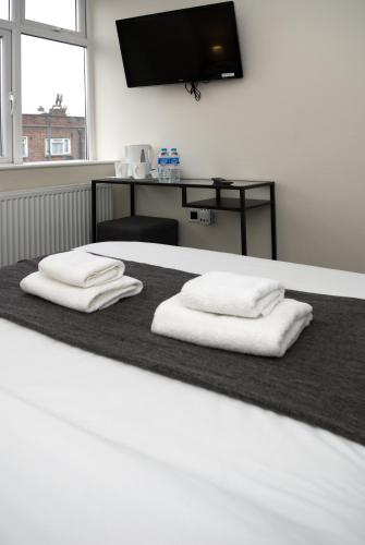 Ένα ή περισσότερα κρεβάτια σε δωμάτιο στο Guest House London