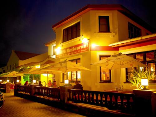 un restaurante con sombrillas frente a un edificio en Hotel Deutsches Haus Swakopmund en Swakopmund