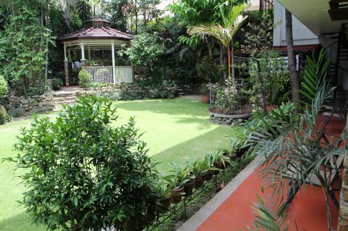 a garden with a gazebo and green grass at New Manila Suites in Manila