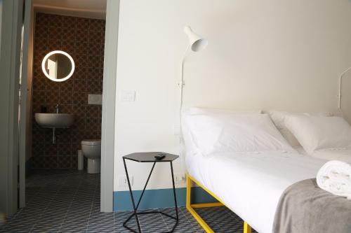 a bedroom with a white bed and a small table at Intervallo Boutique Hotel in Ragusa