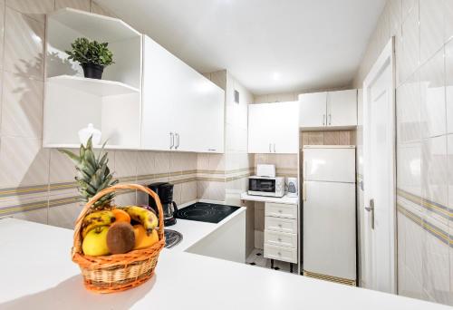 a kitchen with a basket of fruit on a counter at First Flatotel International in Benalmádena