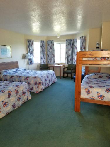 a hotel room with two beds and a desk at Great Lakes Inn Mackinaw City in Mackinaw City