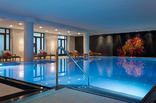 a large swimming pool with a large mirror at Rocco Forte The Charles Hotel in Munich
