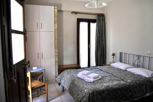 a bedroom with a bed with two towels on it at Filoxenia Studios in Galaxidi