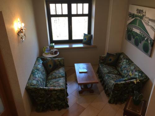 a living room with two couches and a table at Peahen Residence in Sigulda