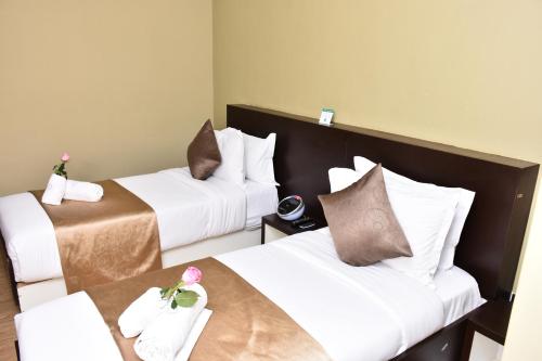a hotel room with two beds and a table at La Maison Royale in Nairobi