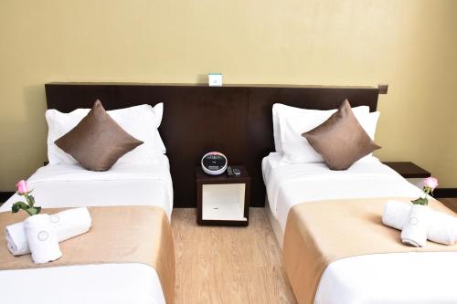 a hotel room with two beds and a clock at La Maison Royale in Nairobi