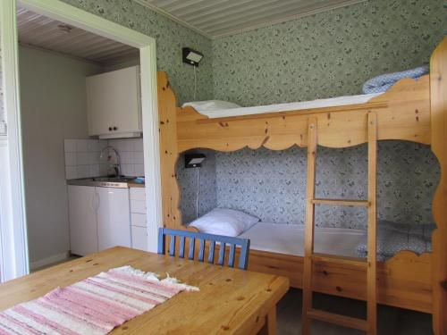 a bedroom with a bunk bed with a table and a dining room at Olsnäsgården in Siljansnäs