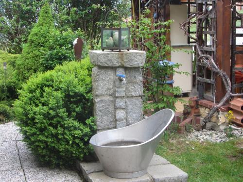 a bath tub in a garden with a fountain at Anna's Home - Ferienwohnungen in Ratsch an der Weinstraße