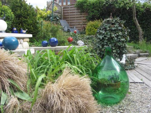 a green glass bottle sitting in the middle of a garden at Anna's Home - Ferienwohnungen in Ratsch an der Weinstraße