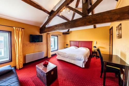 une chambre avec un lit, une table et un canapé dans l'établissement Logis Domaine du Prieuré, à Tonnay-Boutonne