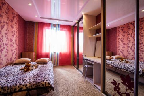 a bedroom with two beds and a mirror at Kirova 115 in Novokuznetsk