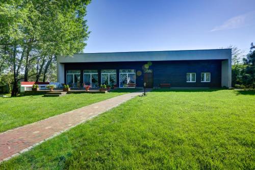 a building with a grassy field in front of it at Biały Pałac Palczew in Palczew