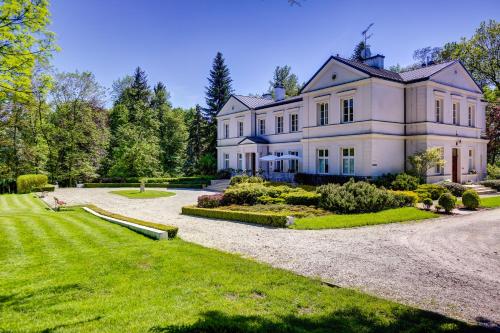 a large white house with a gravel driveway at Biały Pałac Palczew in Palczew