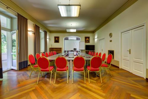 a conference room with a table and red chairs at Biały Pałac Palczew in Palczew