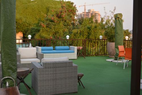 a patio with couches and chairs on a green floor at GuestHouse 1109 in Maputo