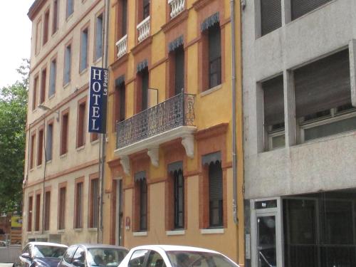 a building with cars parked in front of it at Hôtel le Pastel in Toulouse