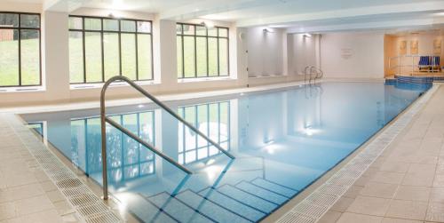 a large swimming pool with stairs in a building at De Vere Latimer Estate in Chesham