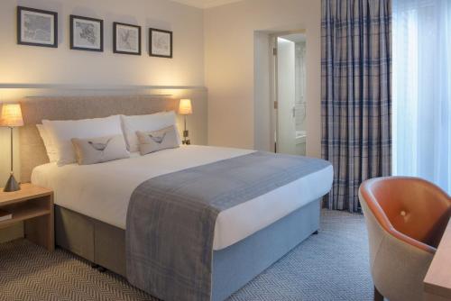 a hotel room with a bed and a chair at De Vere Latimer Estate in Chesham