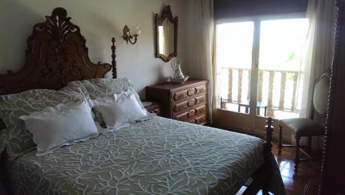 a bedroom with a bed and a window and a dresser at A Casa De Amparo in Sanxenxo