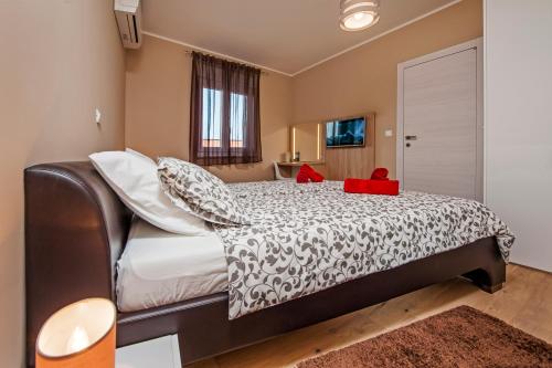 a bedroom with a large bed with a red box on it at Apartment Panoss in Rovinj