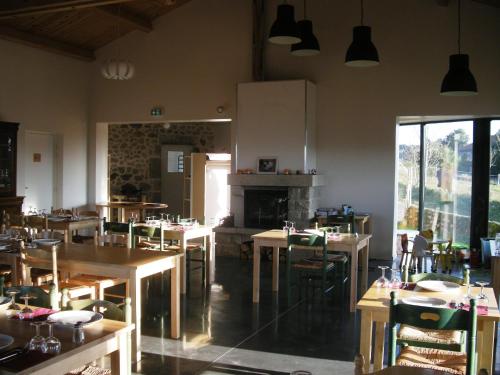un restaurant avec des tables, des chaises et une cheminée dans l'établissement Auberge BRIASSOU, à Grazac