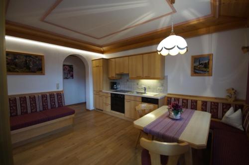 a living room with a table and a kitchen at Landhaus Christophorus in Leogang