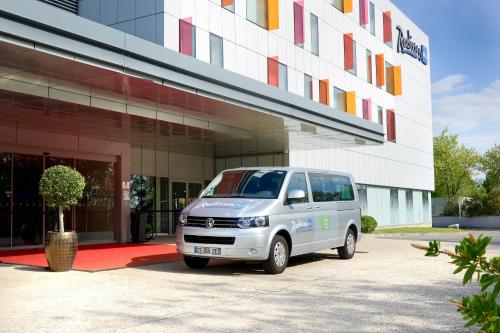 a white van parked in front of a building at Radisson Blu Hotel Toulouse Airport in Blagnac