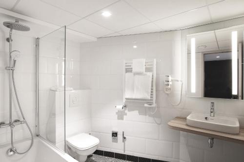 a bathroom with a toilet and a shower and a sink at ibis Styles Laval Centre Gare in Laval