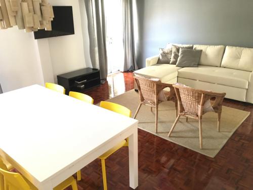 a living room with a couch and a table and chairs at Lemon Tree Apartments in Faro