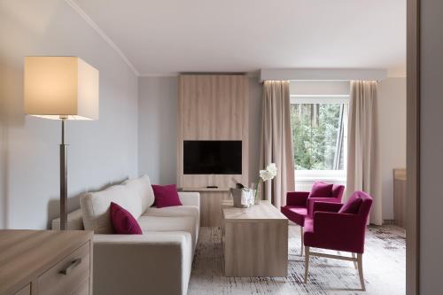 a living room with a white couch and purple chairs at Willa Spa Scaliano in Kudowa-Zdrój