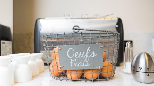 a basket of oranges on a counter with a sign at ibis Styles Laval Centre Gare in Laval