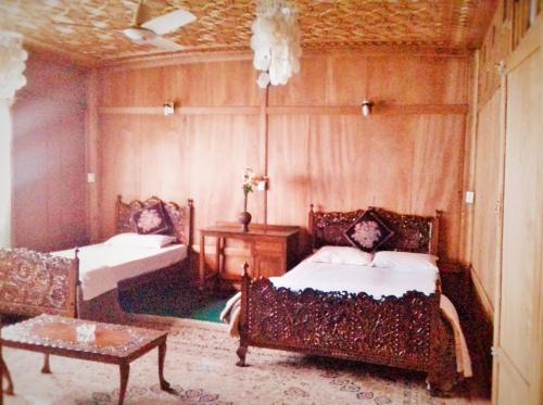 a bedroom with a bed and a couch and a table at Kashmir View group of Houseboat in Srinagar