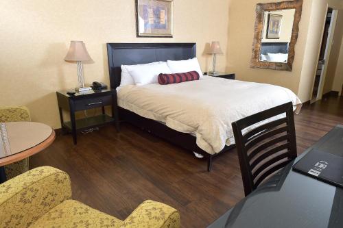 a hotel room with a bed and a table and chairs at Hôtel Le Concorde Québec in Quebec City