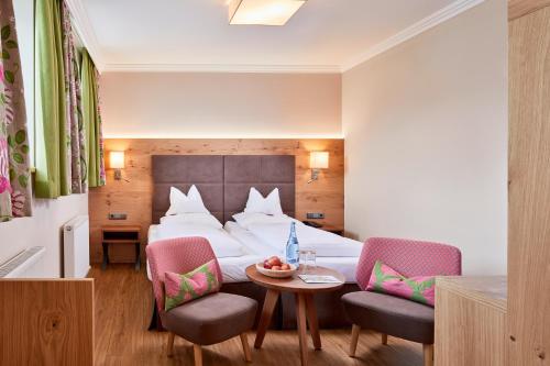 a hotel room with a bed and a table and chairs at Hotel Neue Post in Mayrhofen