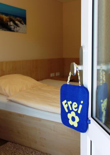 a sign hanging on a door with a bed at Pension Am Ziegelwall in Bautzen