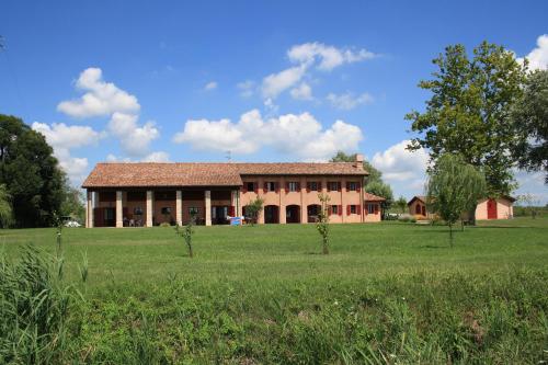 ein großes Gebäude mit einem Feld davor in der Unterkunft Agriturismo Ca' Lealtà in Marango di Caorle – Casa Pace