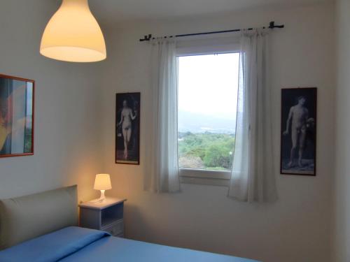 バデージにあるSea House Sardinia - Casa Amethistaのベッドルーム(ベッド1台、窓付)